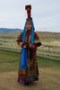 Frau in mongolischer Tracht, die den typischen Segen mit Stutenmilch gibt